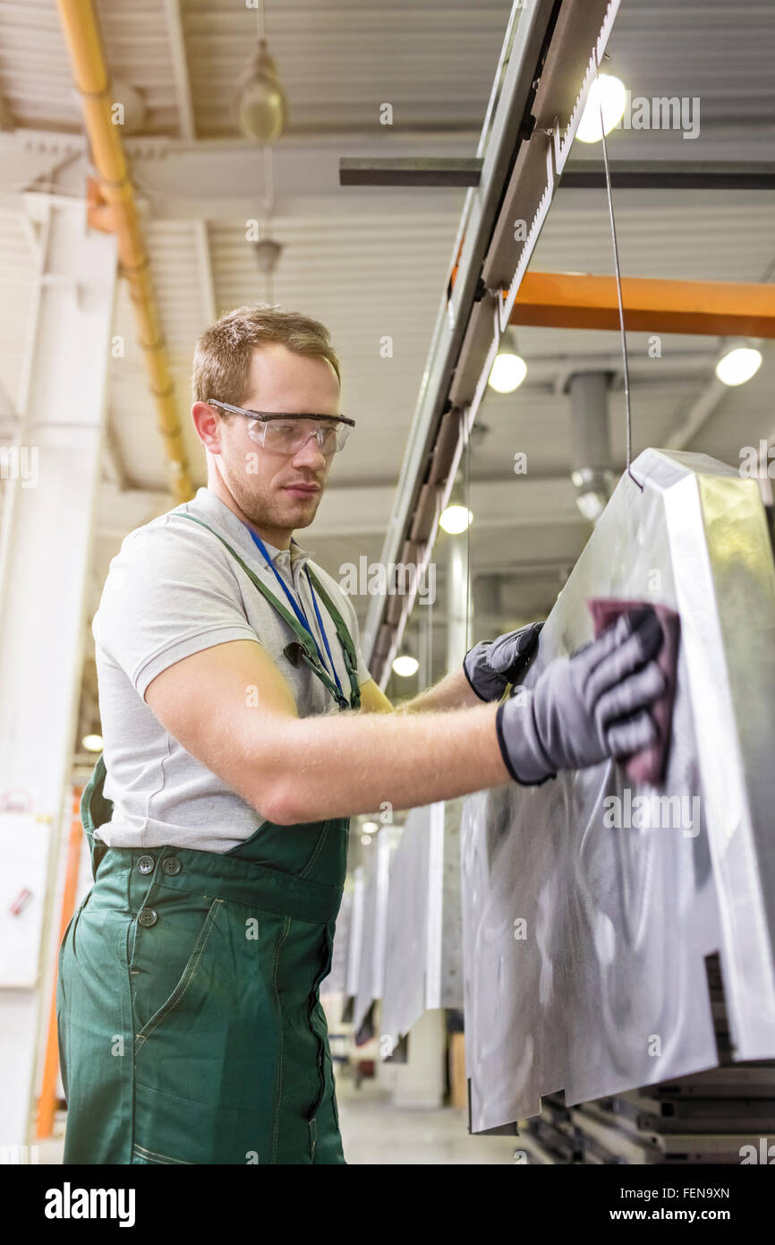 Worker sanding steel part in factory Stock Photo Alamy