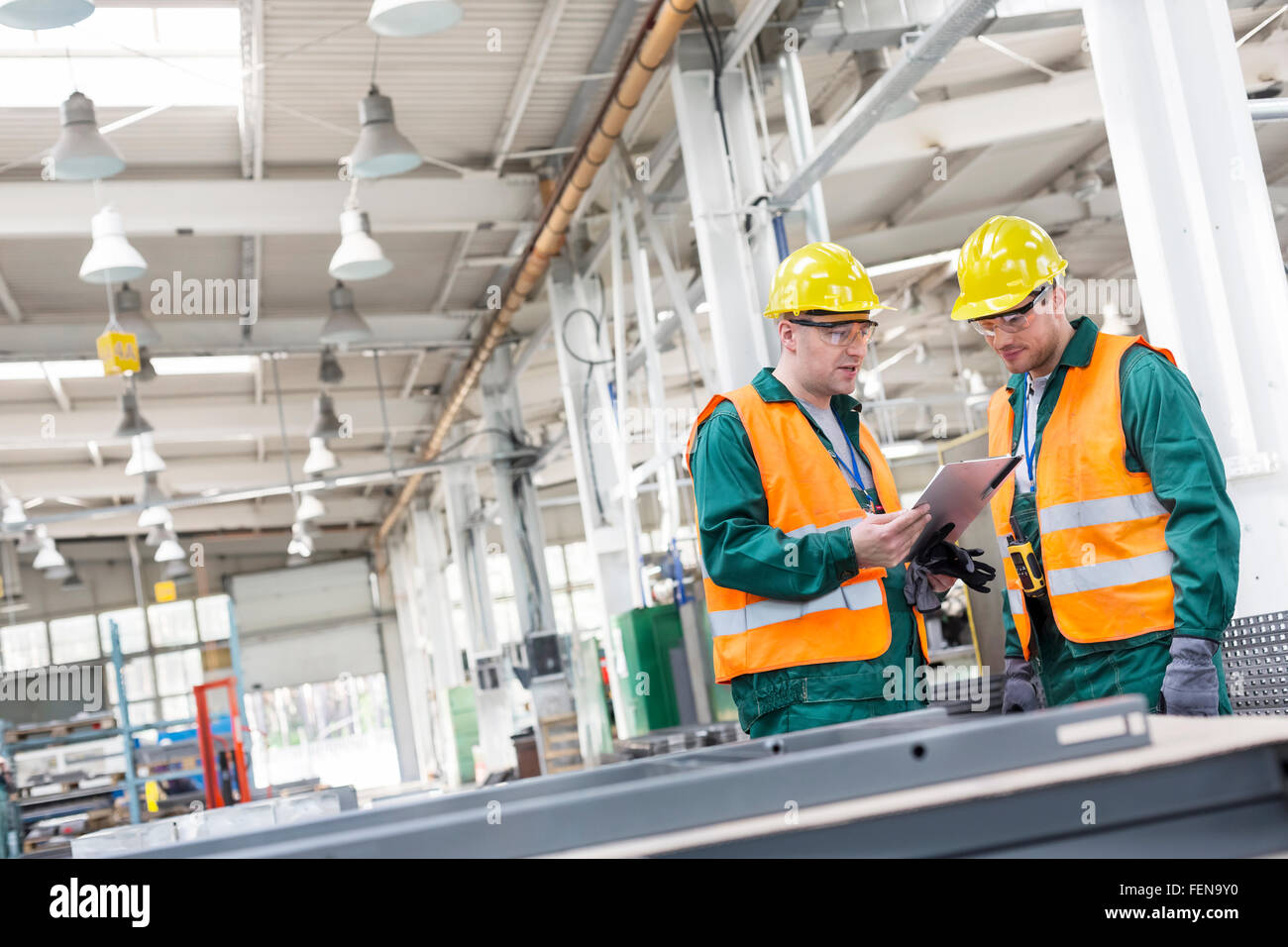 Workers in protective workwear with clipboard in factory Stock Photo