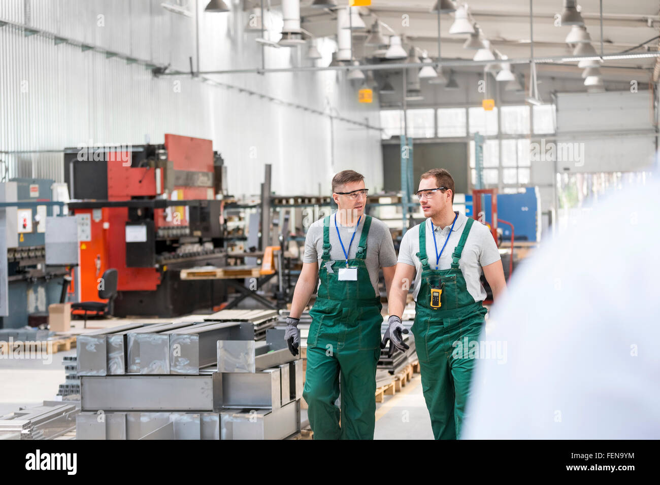 Workers walking and talking in factory Stock Photo