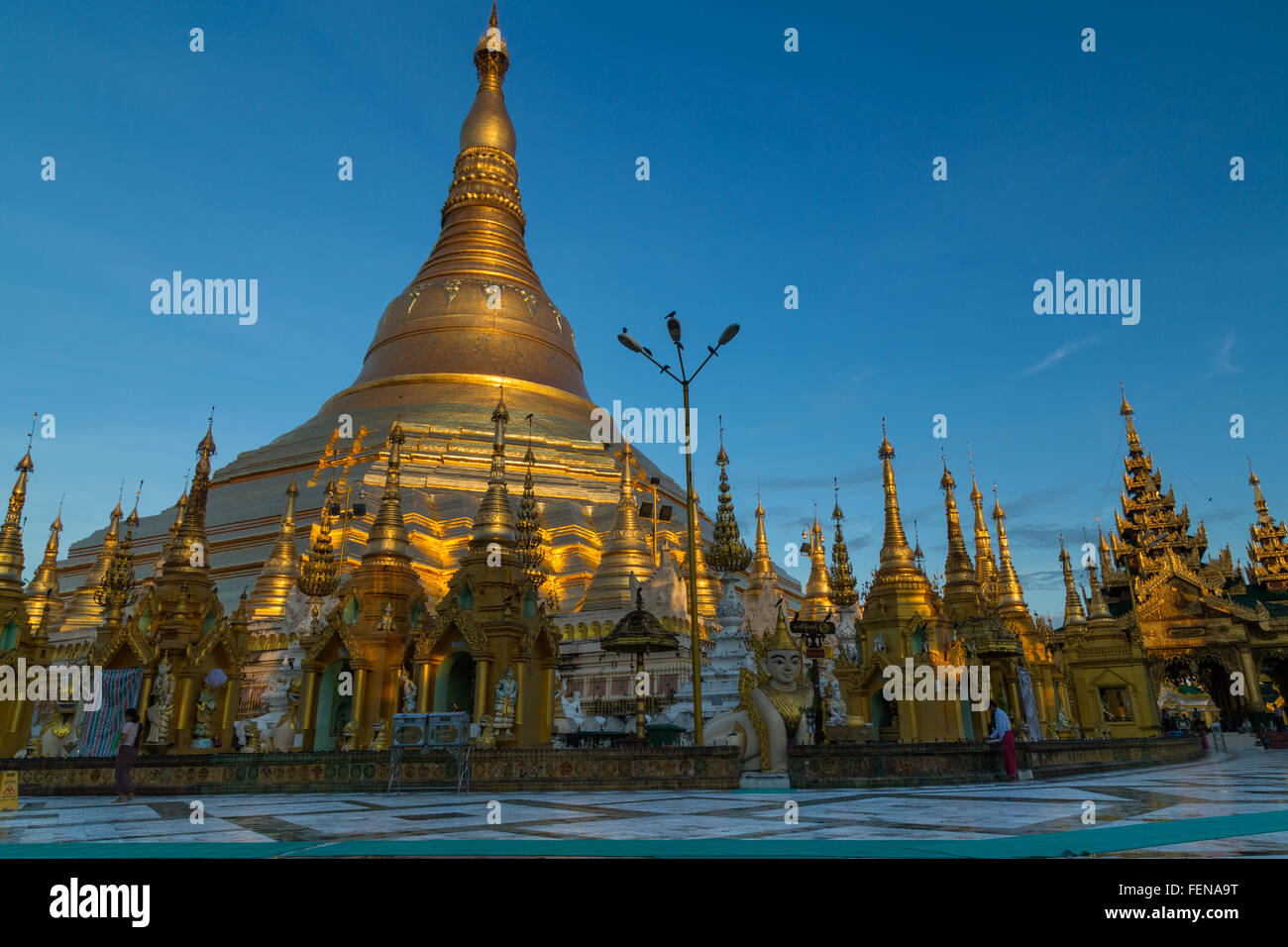 The iconic Shwedagon pagoda glows in a beautiful soft gold light at dawn - landscape Stock Photo