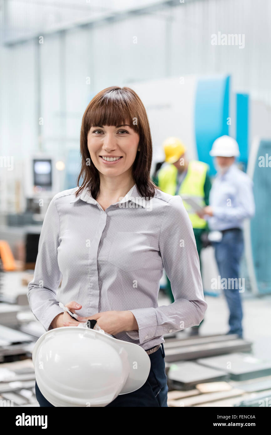 Portrait smiling engineer with hard-hat in factory Stock Photo