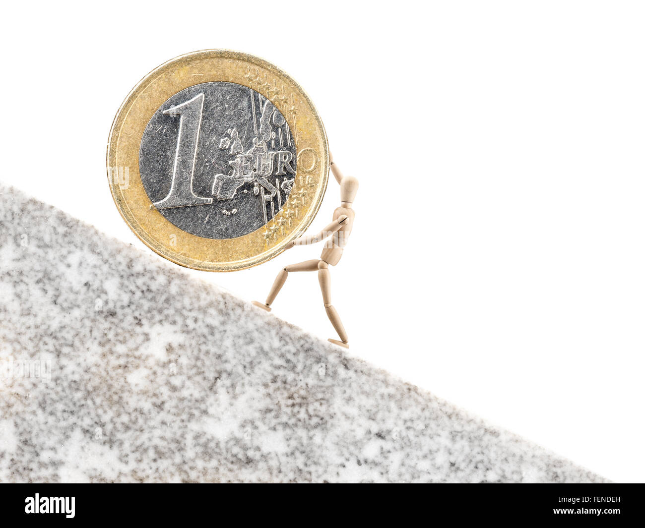One Euro coin being rolled upwards on inclined plane by wooden dummy on white background Stock Photo
