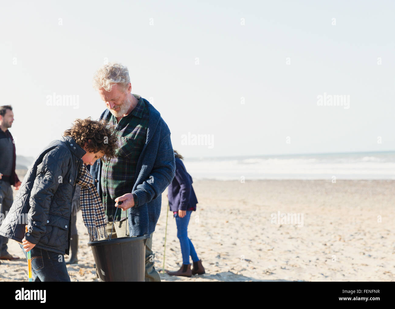 Multi-generation family clam digging on sunny beach Stock Photo
