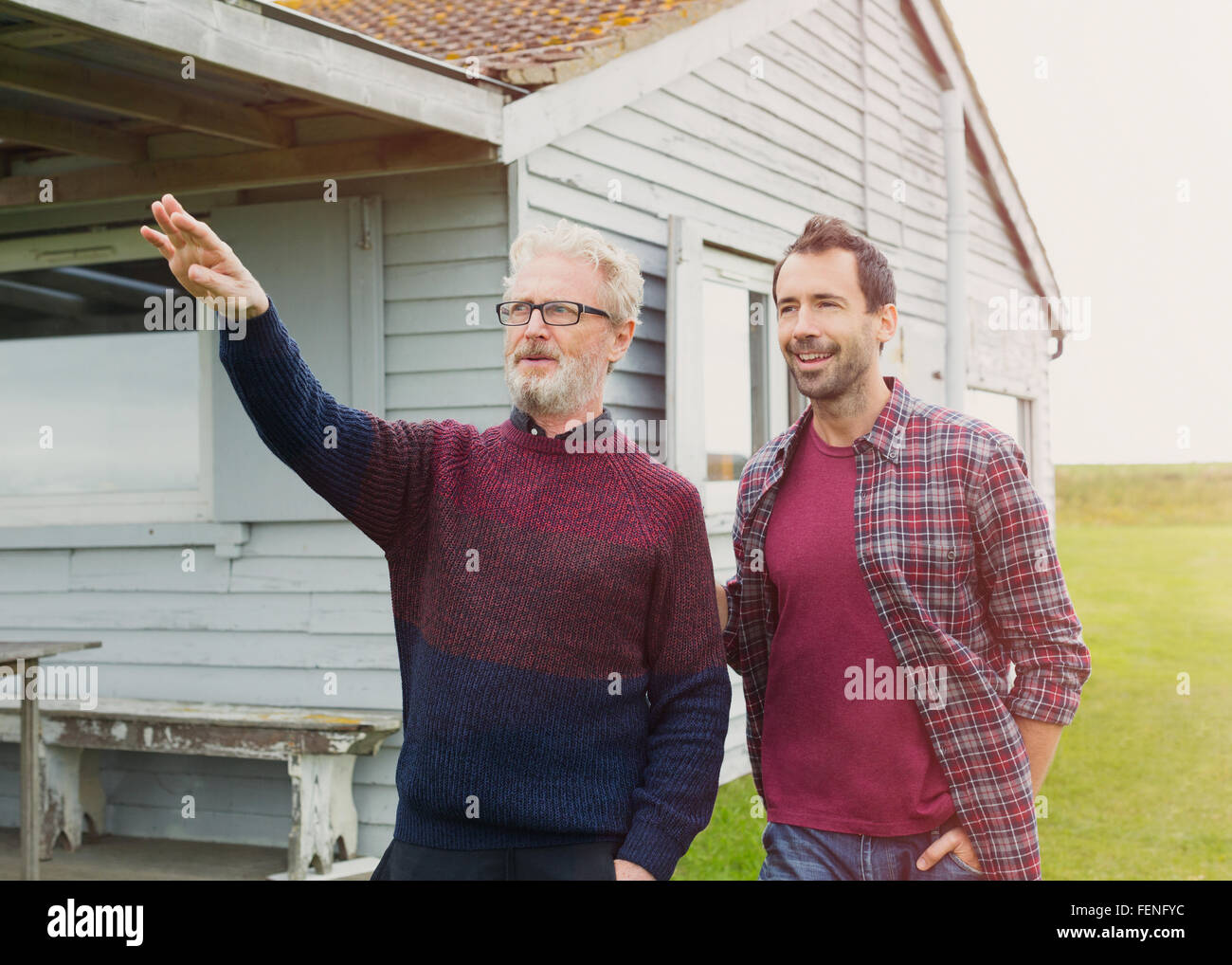 Father gesturing to son outside house Stock Photo
