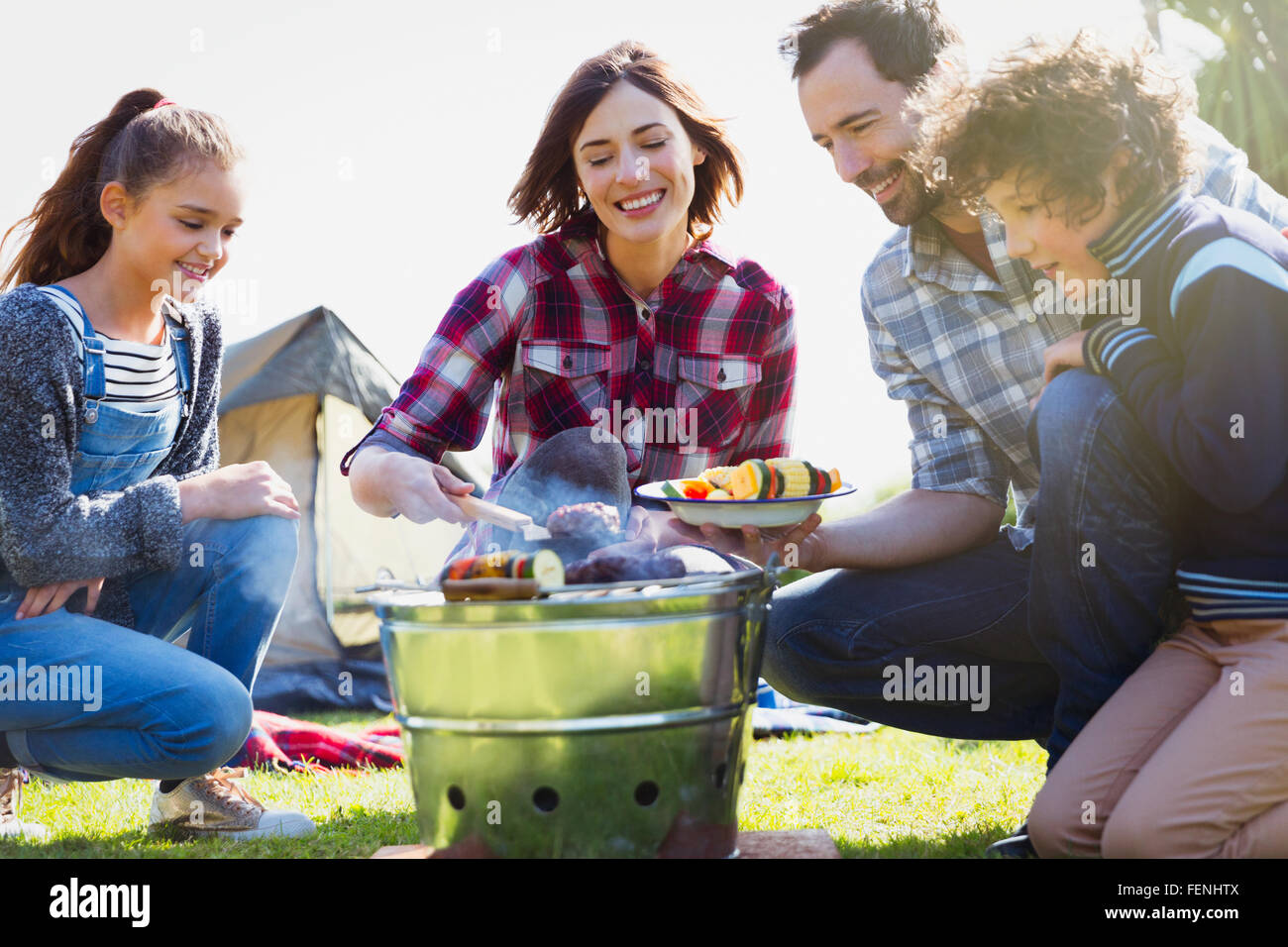 Family barbecuing at campsite grill Stock Photo