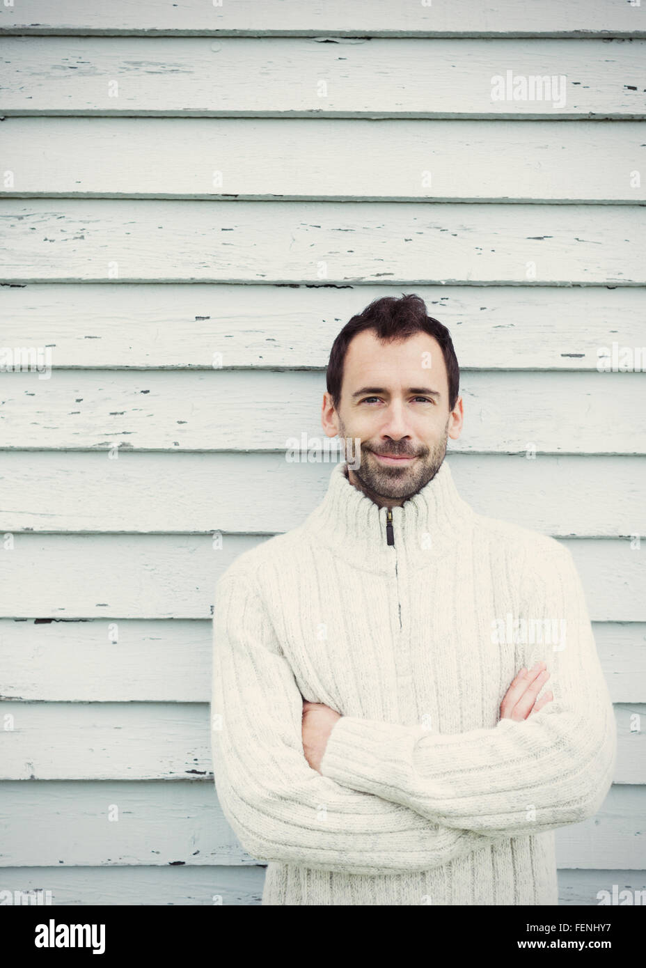 Portrait brunette man in sweater with arms crossed Stock Photo