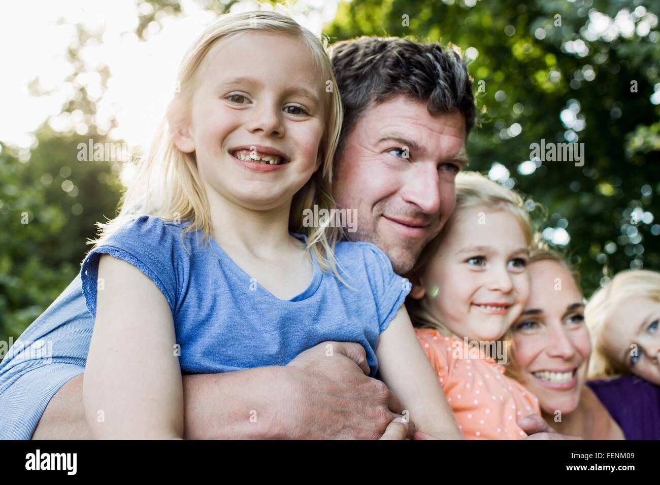 Portrait of parents and three young daughters in park Stock Photo