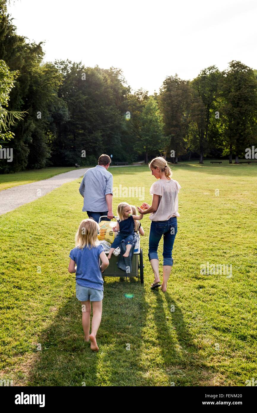 Rear view of parents and three girls strolling in park Stock Photo
