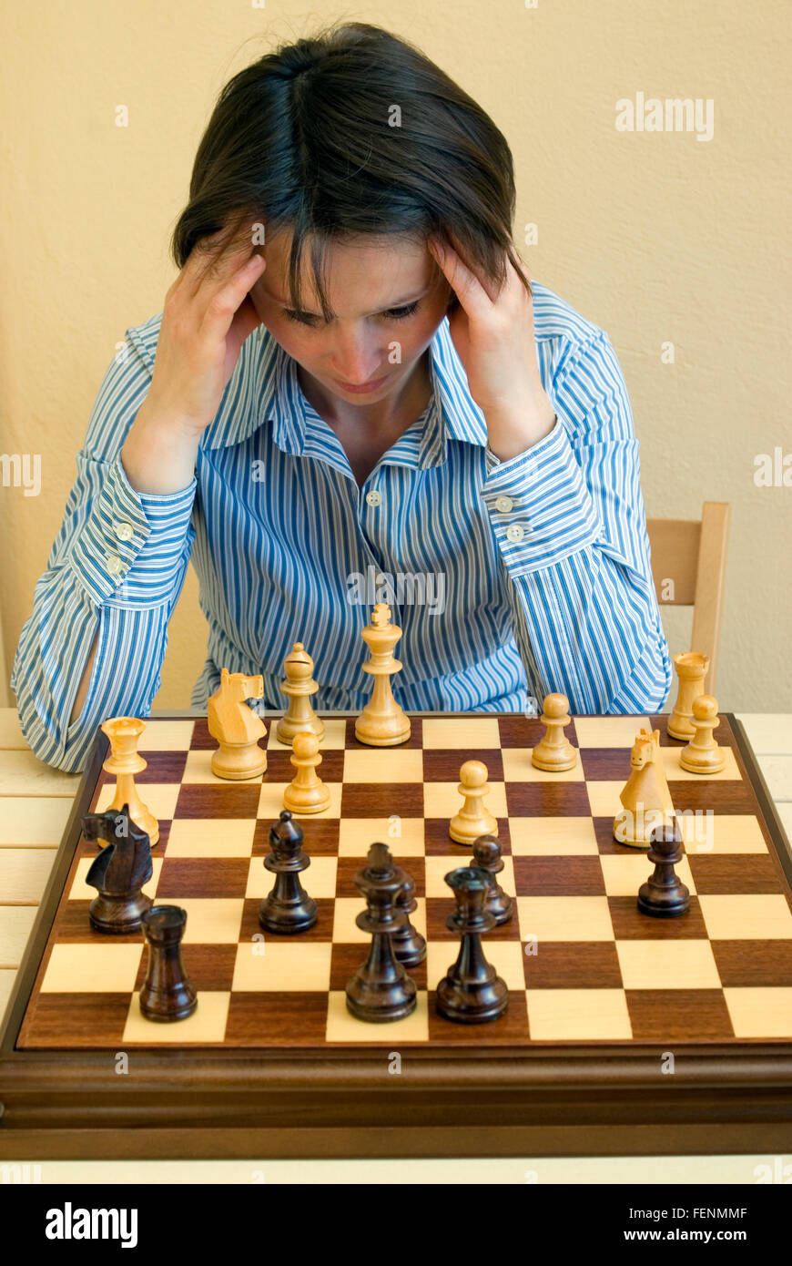 Woman playing chess thinking of next move Stock Photo - Alamy