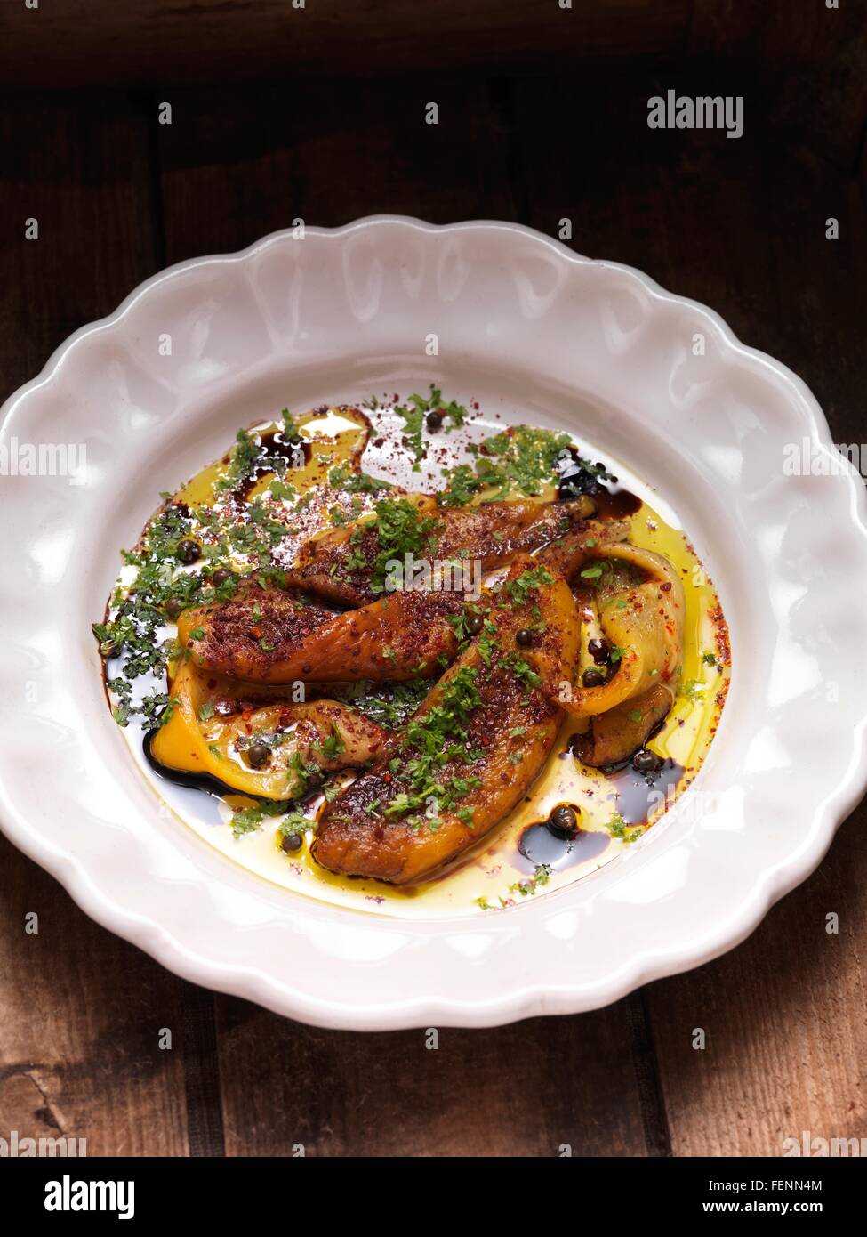 Olive oil and balsamic vinegar marinated green and yellow peppers in a bowl Stock Photo