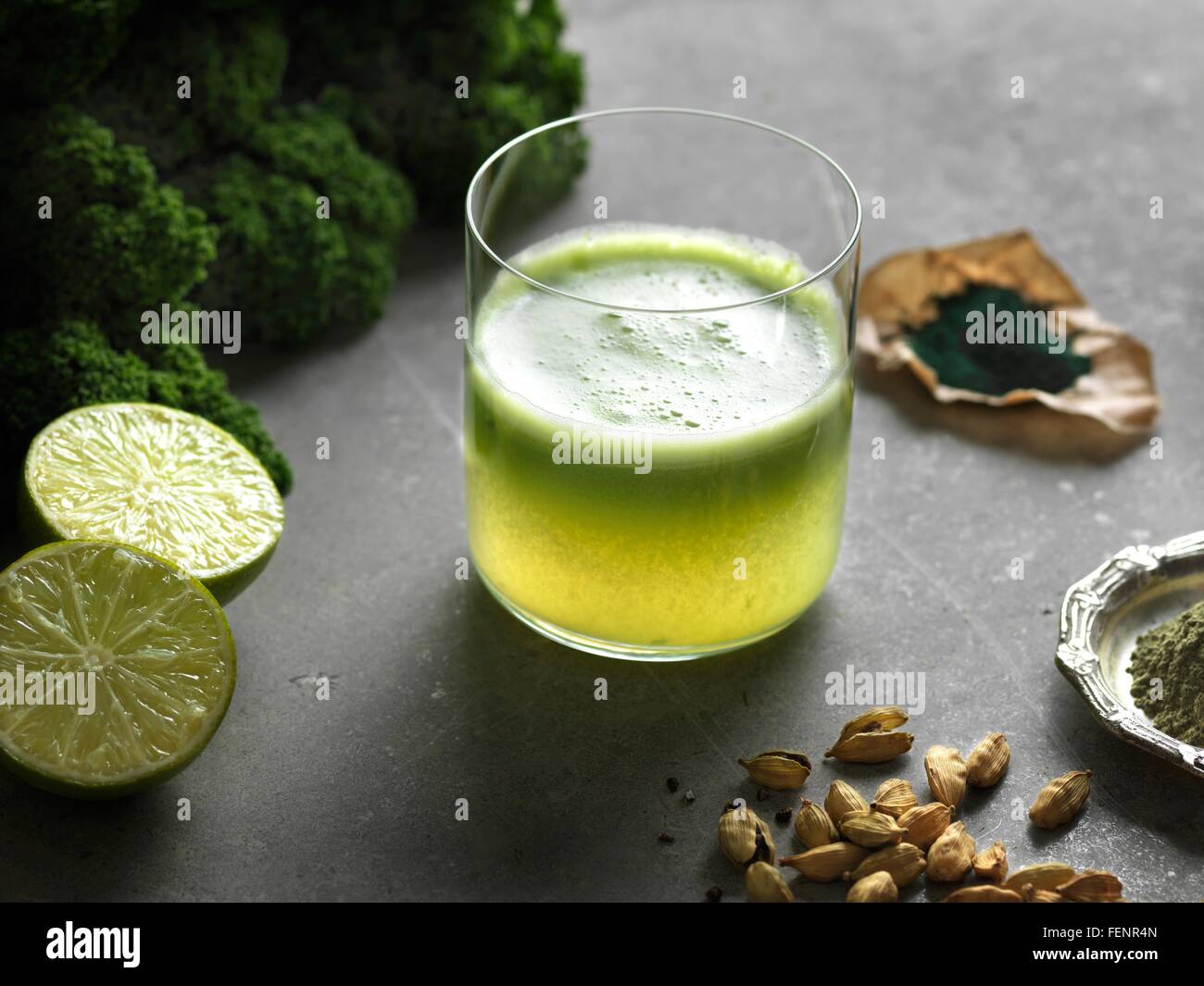 High angle view of green raw juice with halved lime and nutritional supplement Stock Photo