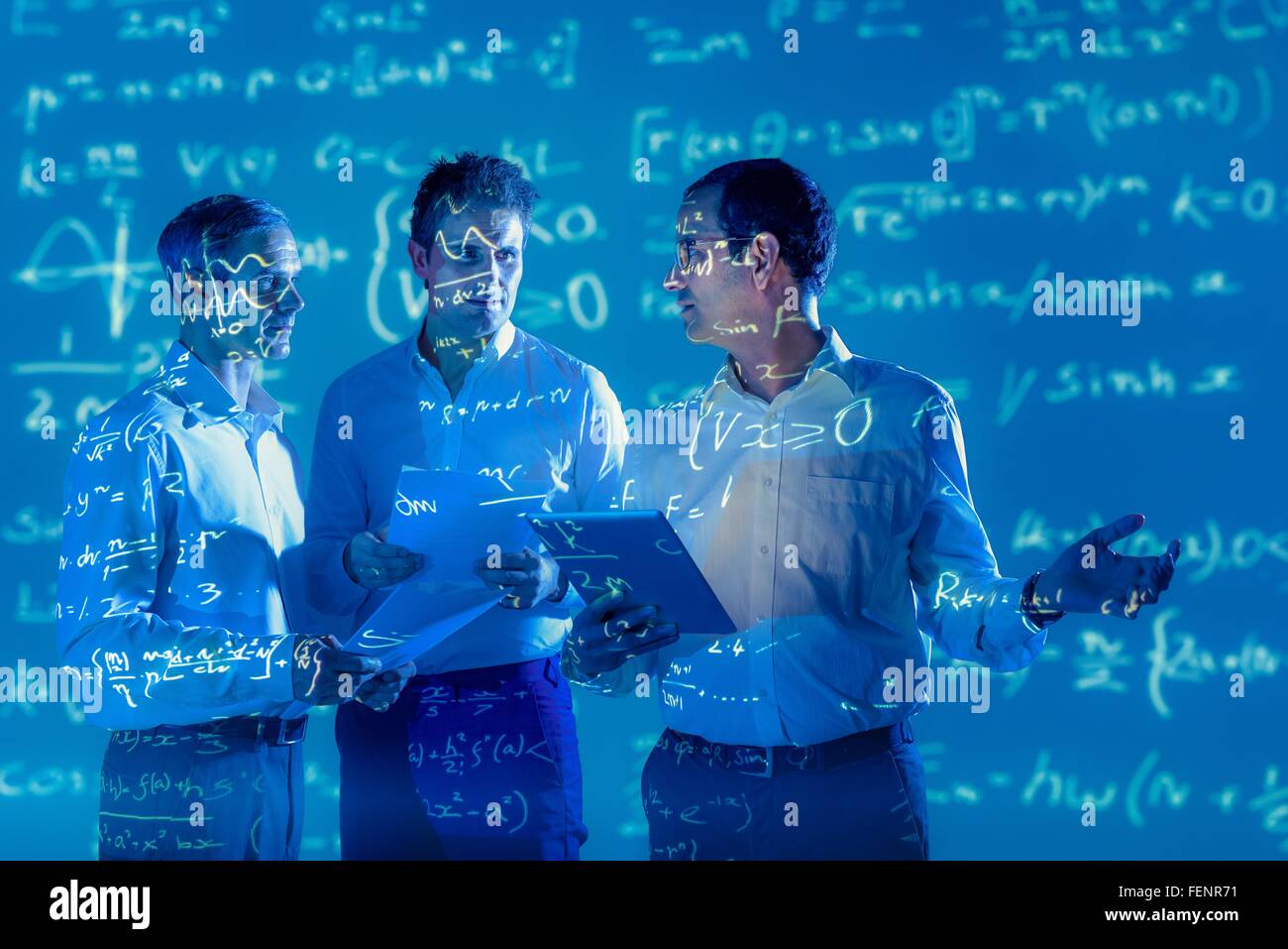 Scientists with projected mathematical data Stock Photo