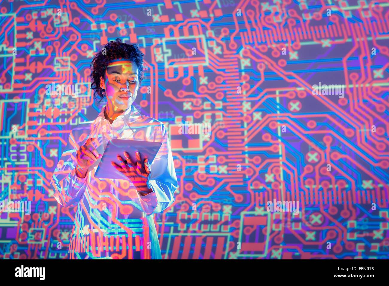 Female scientist using digital tablet with graphical electronic circuit projection Stock Photo