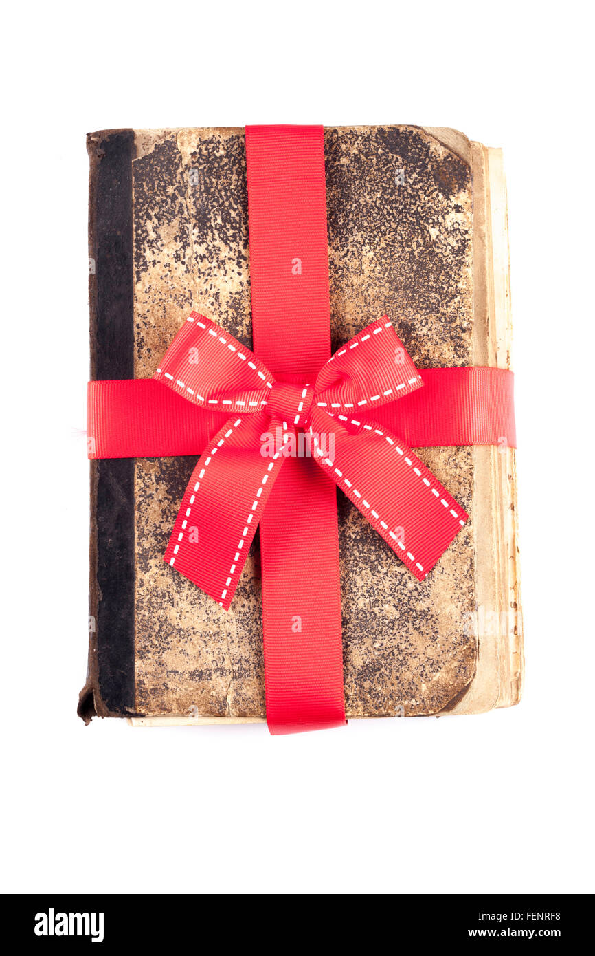 old book as a gift with red ribbon isolated Stock Photo