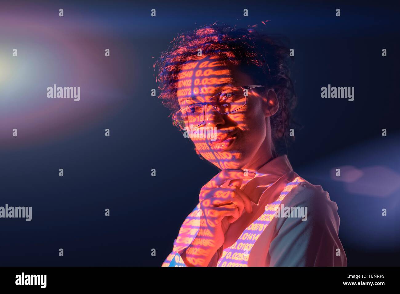 Businesswoman in thought with projected financial numbers on dark background Stock Photo