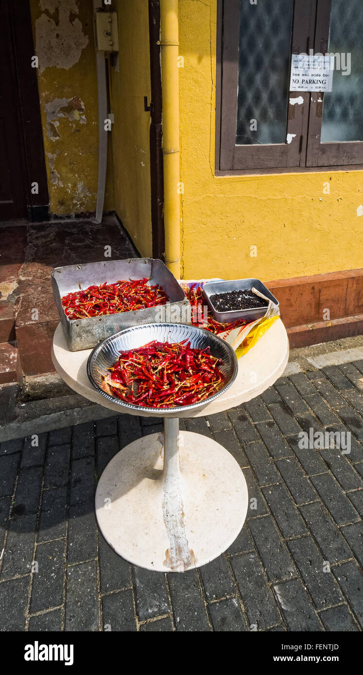 Red chilies and black pepper drying in the sun on a street in Galle, Sri Lanka Stock Photo