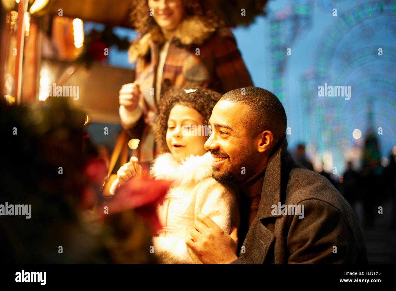 Young family at funfair at night, having fun Stock Photo
