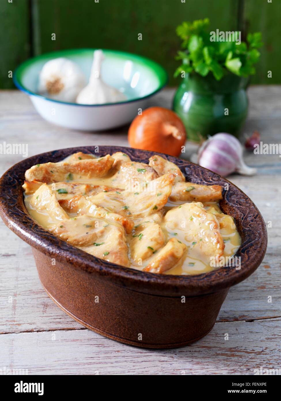 Casserole dish with turkey casserole, garlic, onion and green herbs Stock Photo