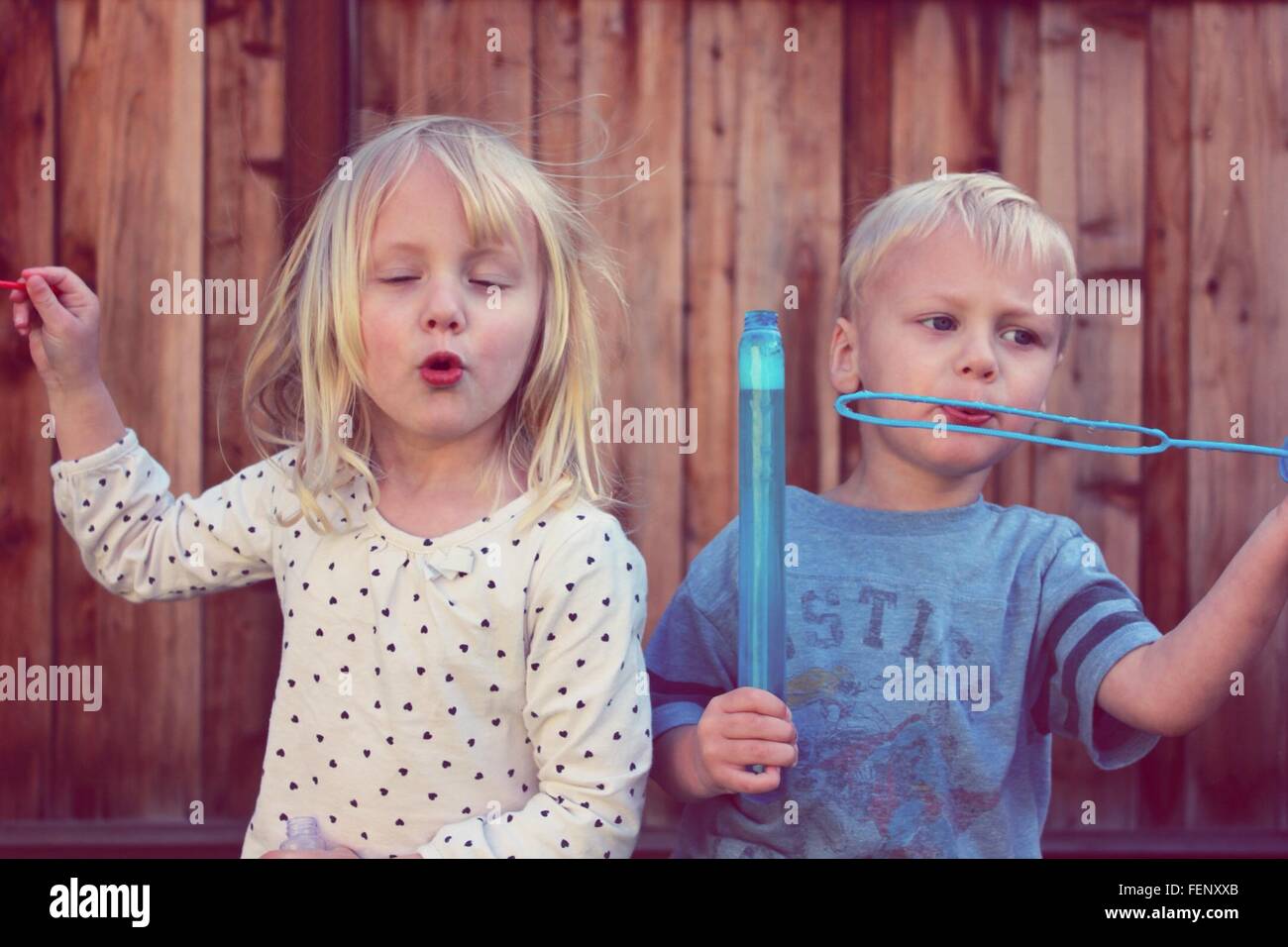 Sibling Playing With Bubbles Backyard Stock Photo