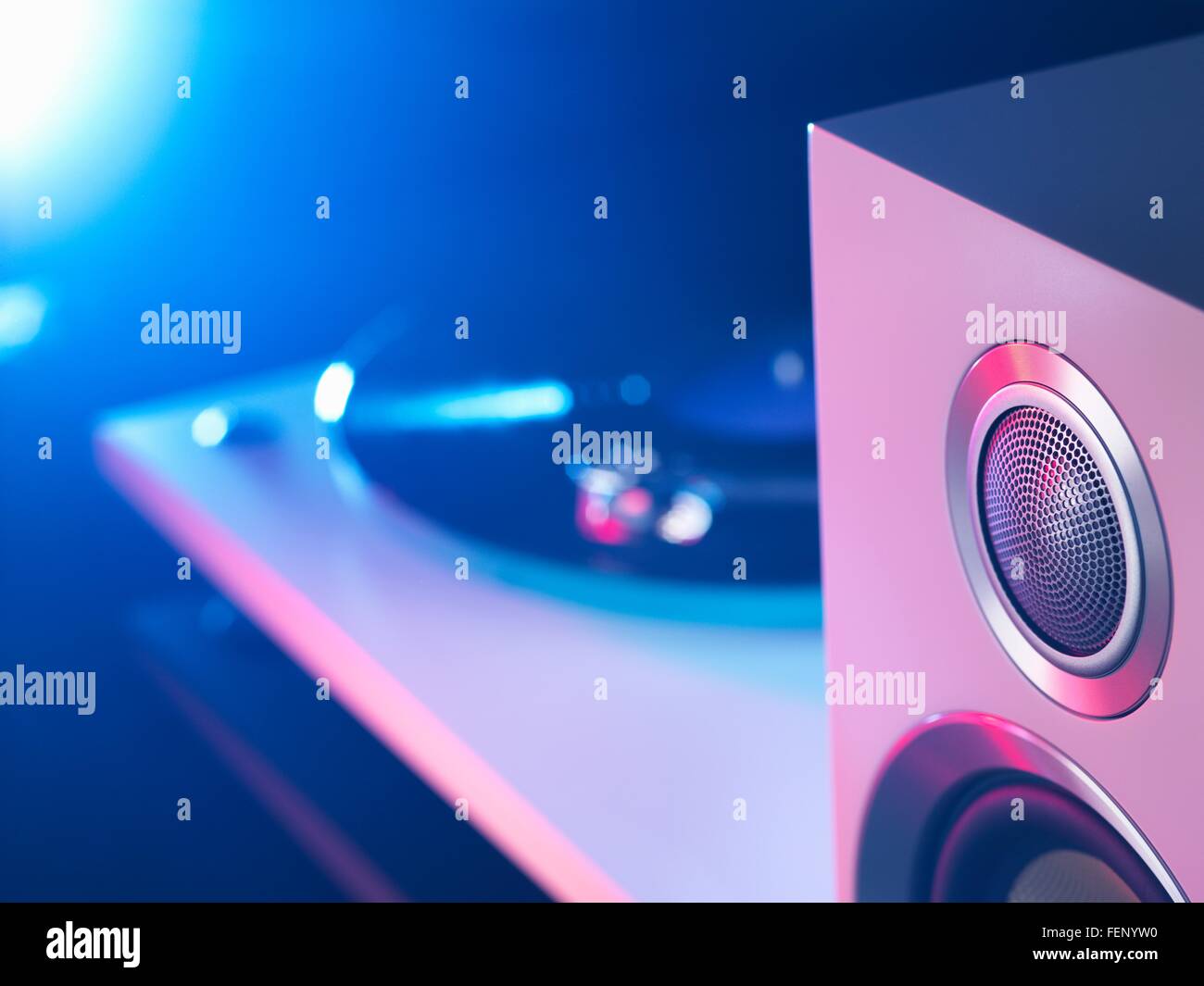 Detail of purple and blue spot lit hi fi speaker and turntable  playing a vinyl record Stock Photo