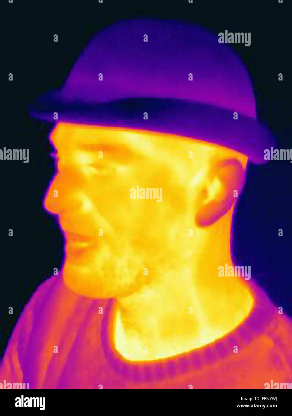 Thermal image of young man wearing face mask and hat Stock Photo