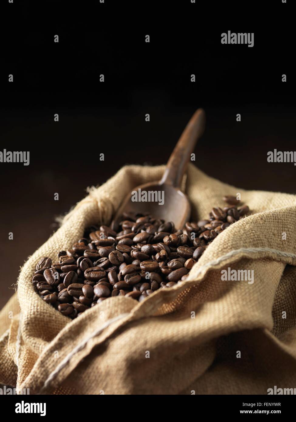 Coffee beans and wooden scoop in woven sack Stock Photo