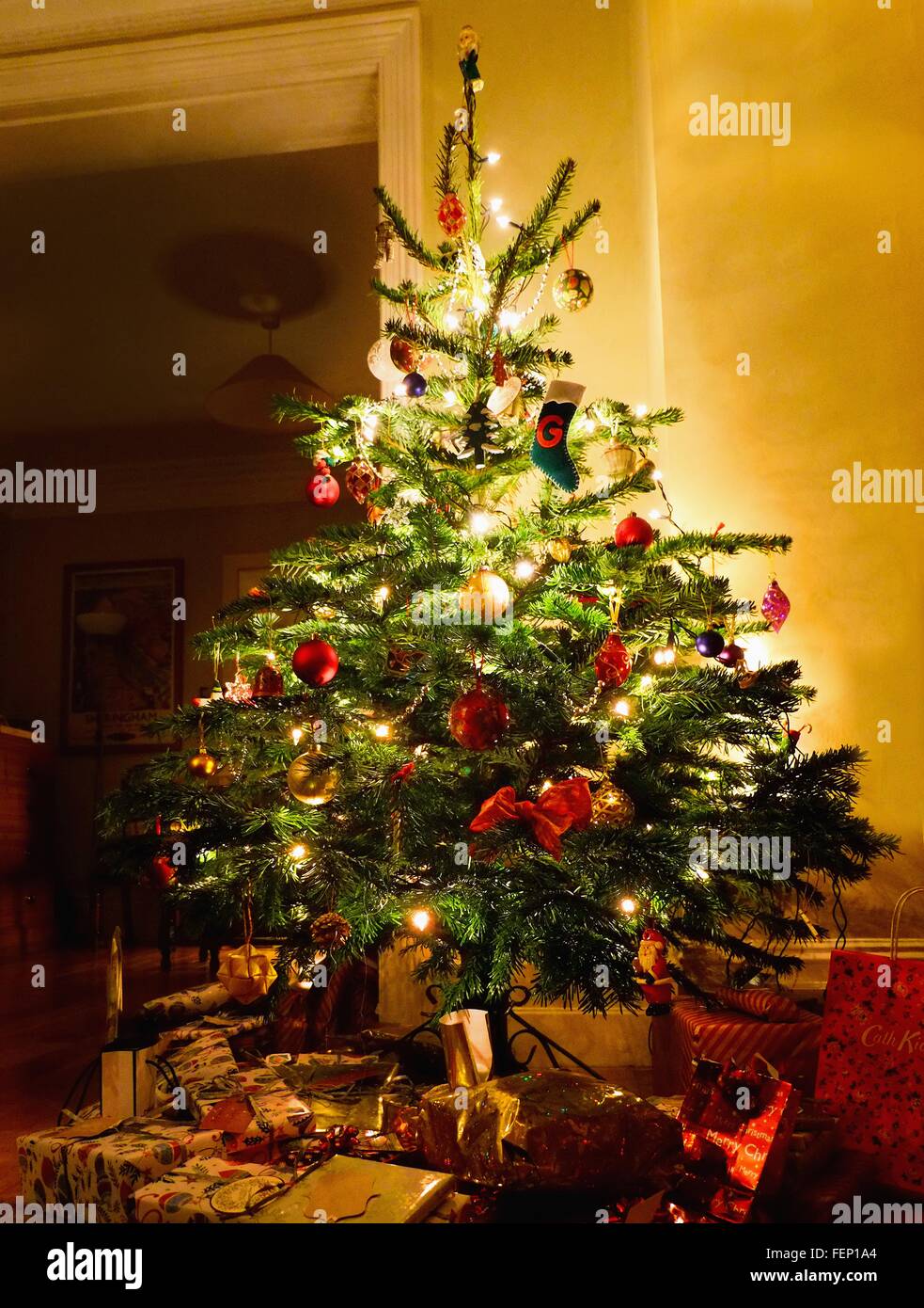 Illuminated christmas tree with gifts underneath Stock Photo Alamy