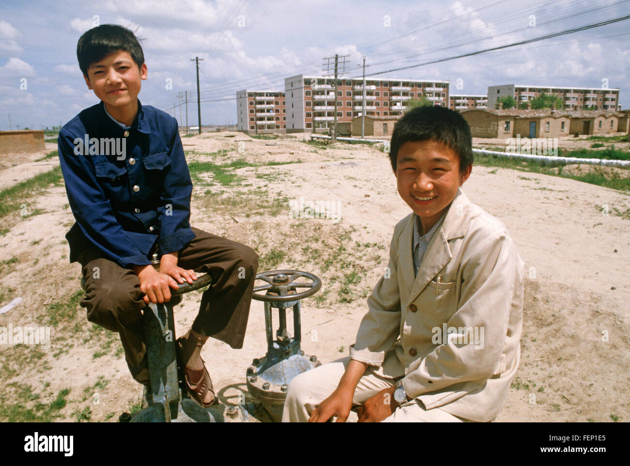 Children playing on oil field installations, Daqing, Heilongjiang Province, China Stock Photo