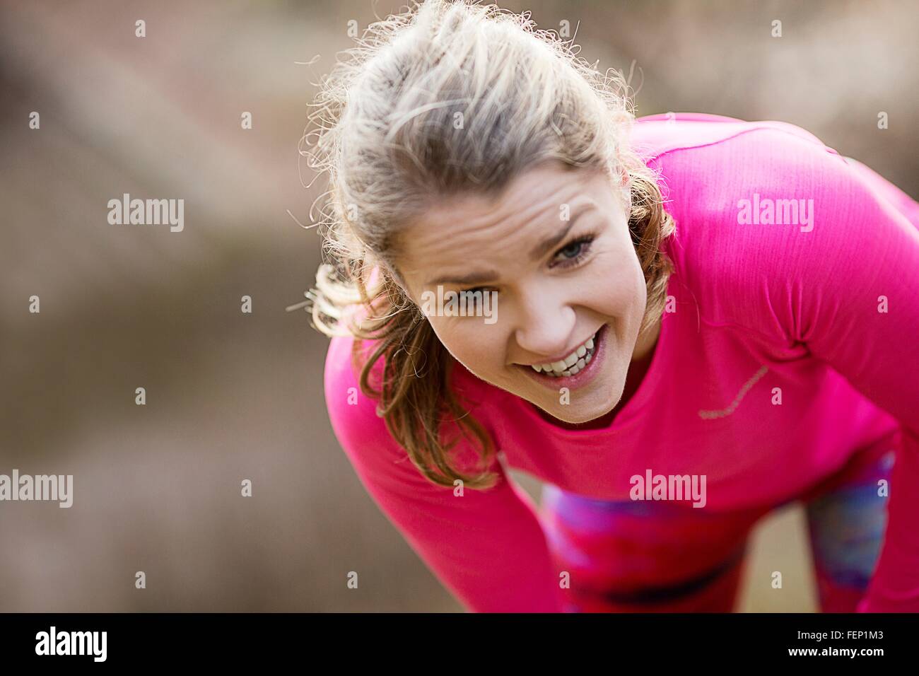 Young woman wearing sportswear bending over exhausted Stock Photo
