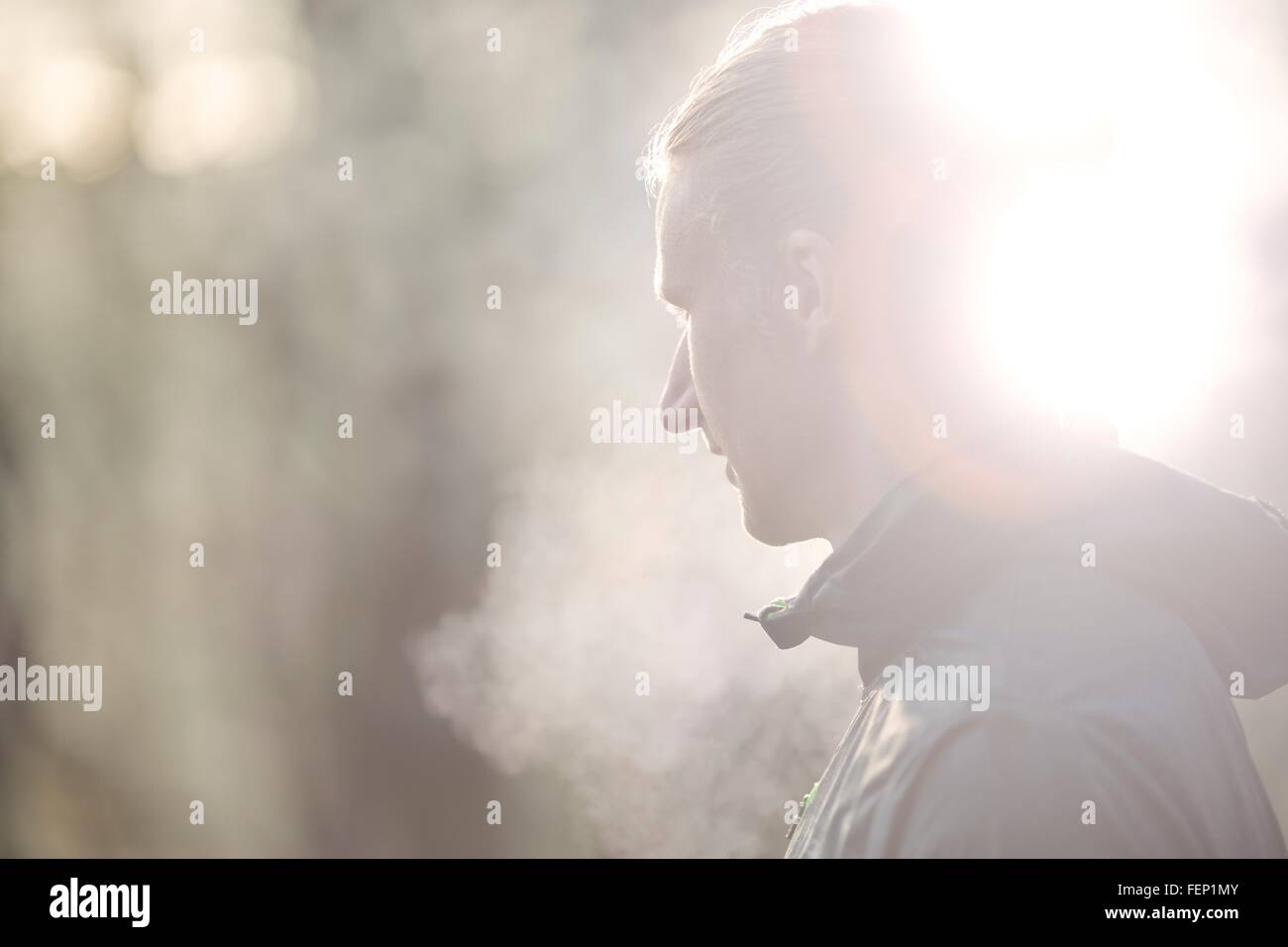 Side view of mid adult man looking away, condensation from breath Stock Photo