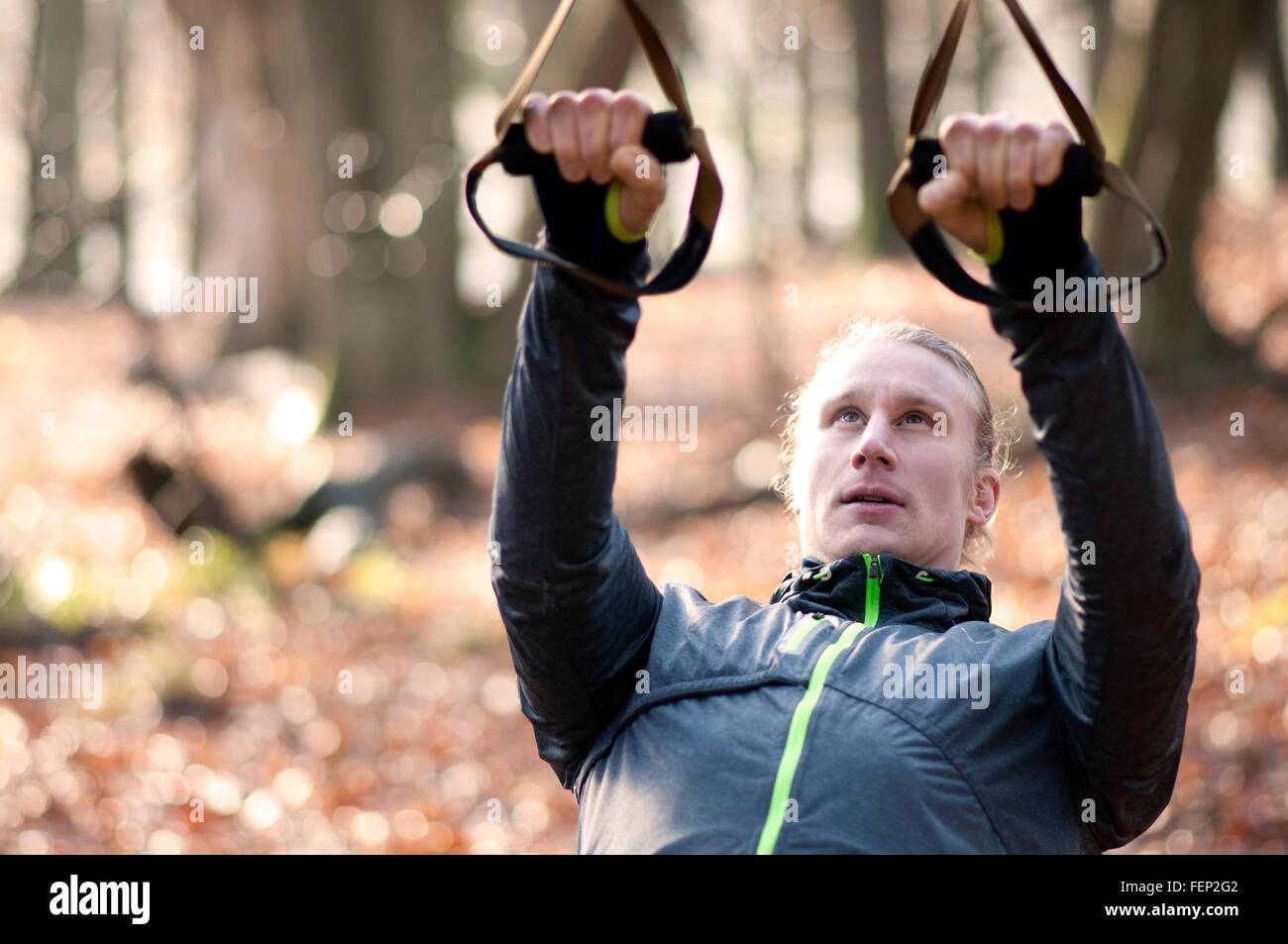 Mid adult man using resistance bands, looking up Stock Photo