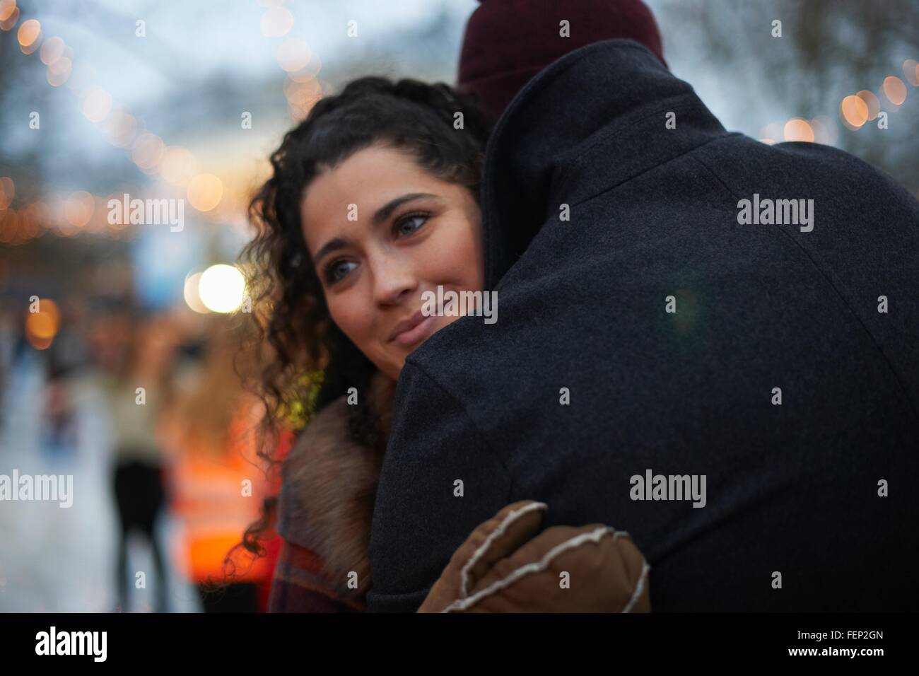 Young woman hugging mid adult man looking away smiling Stock Photo