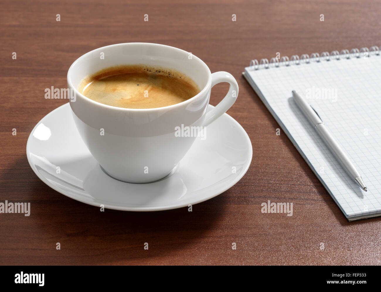 Cup of aromatic coffee americano with notepad and pen. Stock Photo