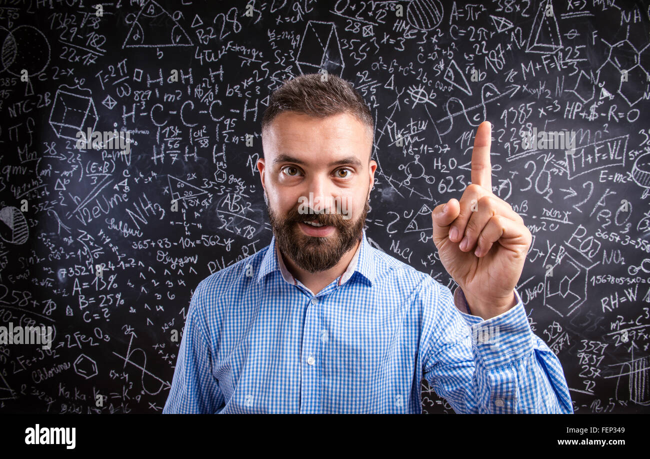 Scolding teacher against big blackboard with mathematical symbol Stock Photo