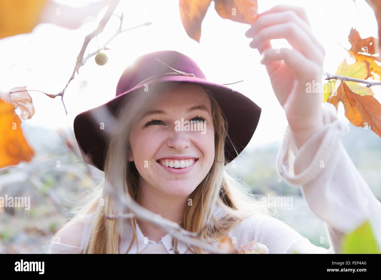 Young woman holding leaf, smiling, outdoors Stock Photo - Alamy