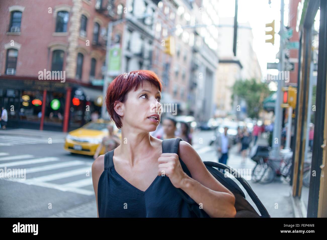 Mature woman looking over her shoulder on city street Stock Photo