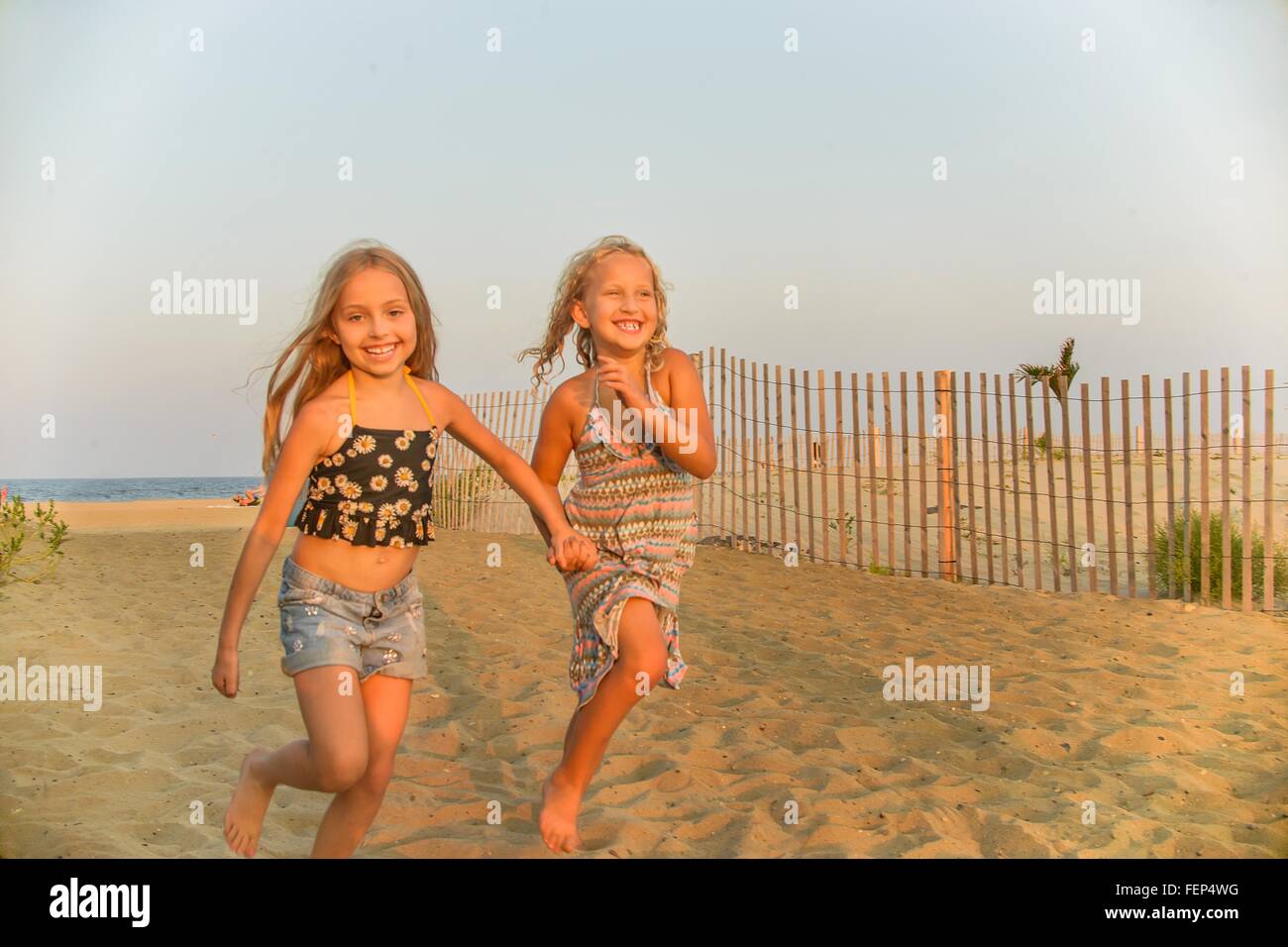 Two girls running holding hands hi-res stock photography and images - Alamy