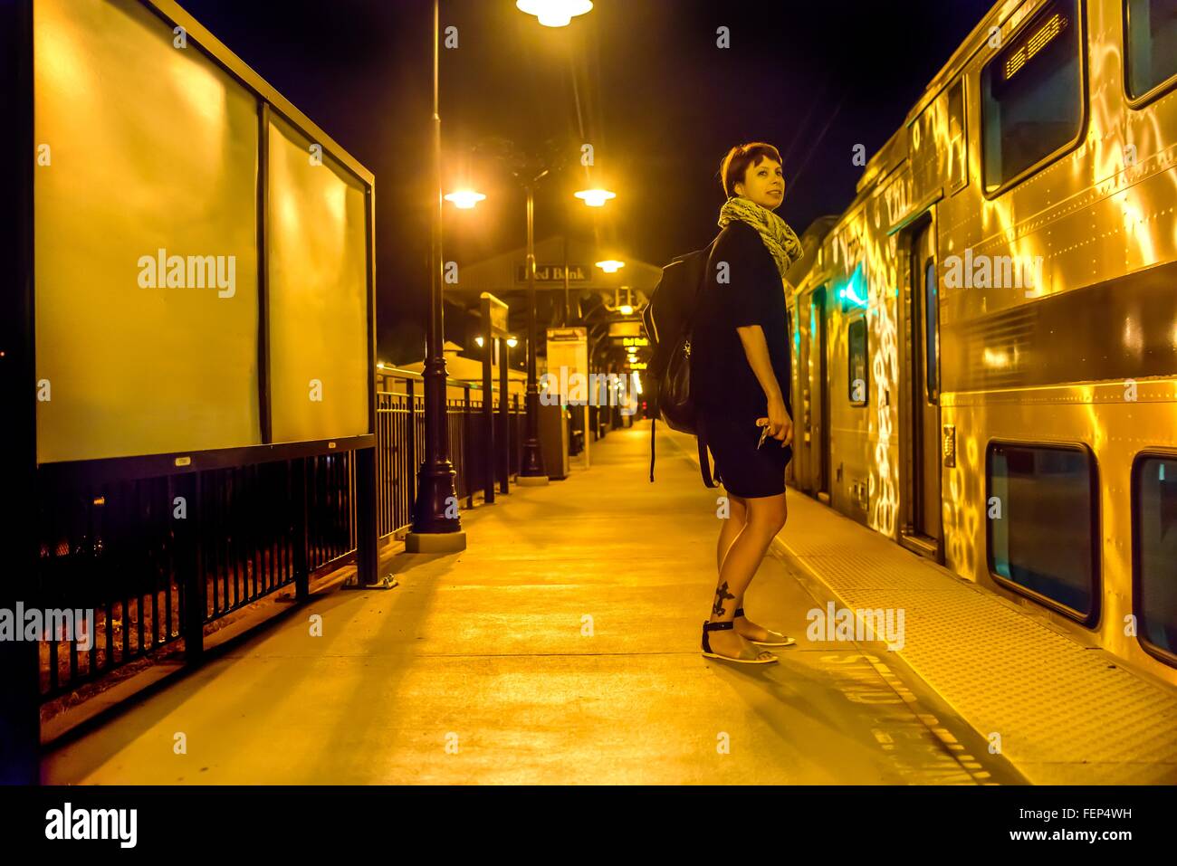 Mature woman standing on train platform at night Stock Photo - Alamy