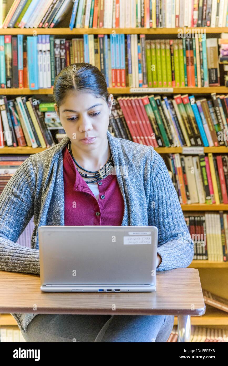 Mature female student using laptop in library Stock Photo
