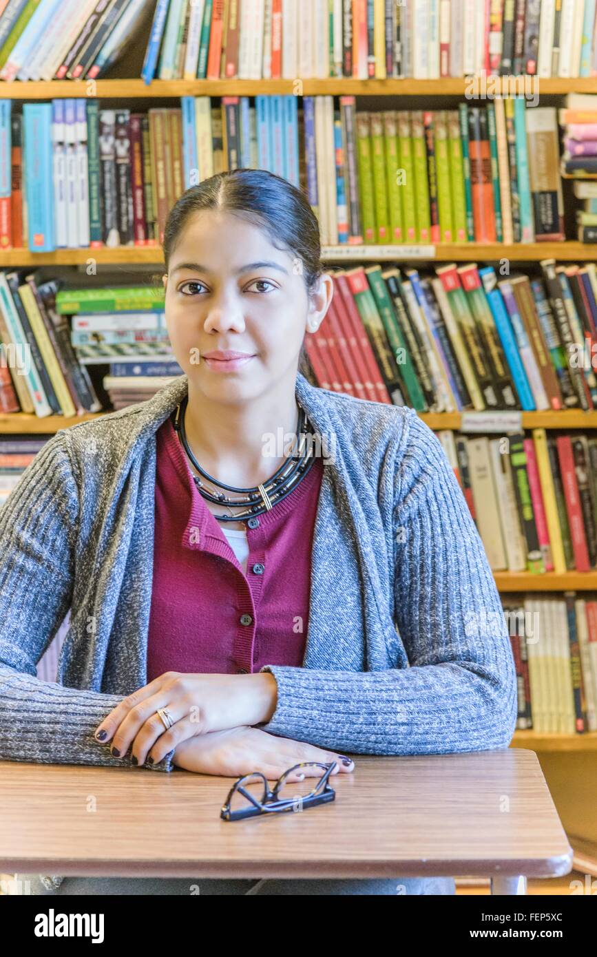 Portrait of mature female student in front of bookshelf Stock Photo