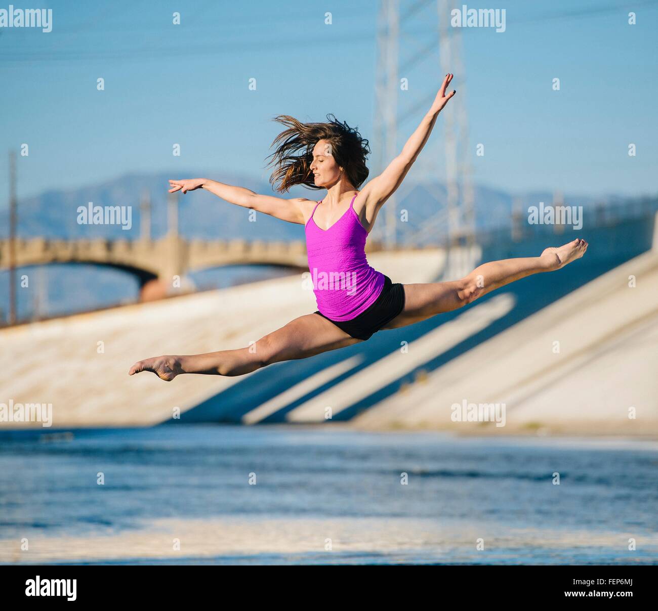 Dancer in mid air, arms raised doing the splits, Los Angeles, California, USA Stock Photo