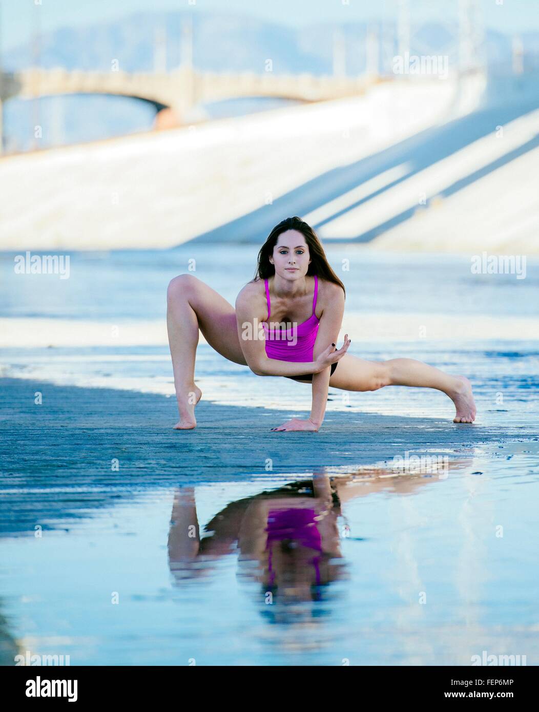 Front view of dancer, open legs, resting on hands, bending forward, poised, looking at camera, Los Angeles, California, USA Stock Photo