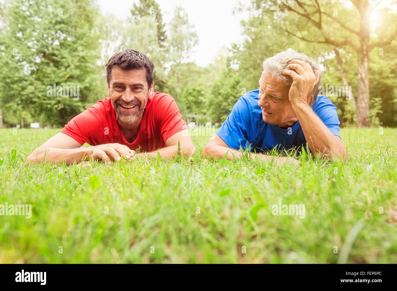 Two men relaxing on grass following exercise Stock Photo