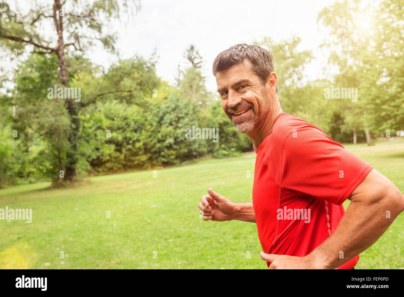 Mature man running outdoors, smiling Stock Photo