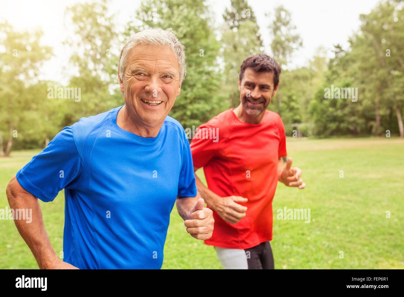 Two men running outdoors, smiling Stock Photo