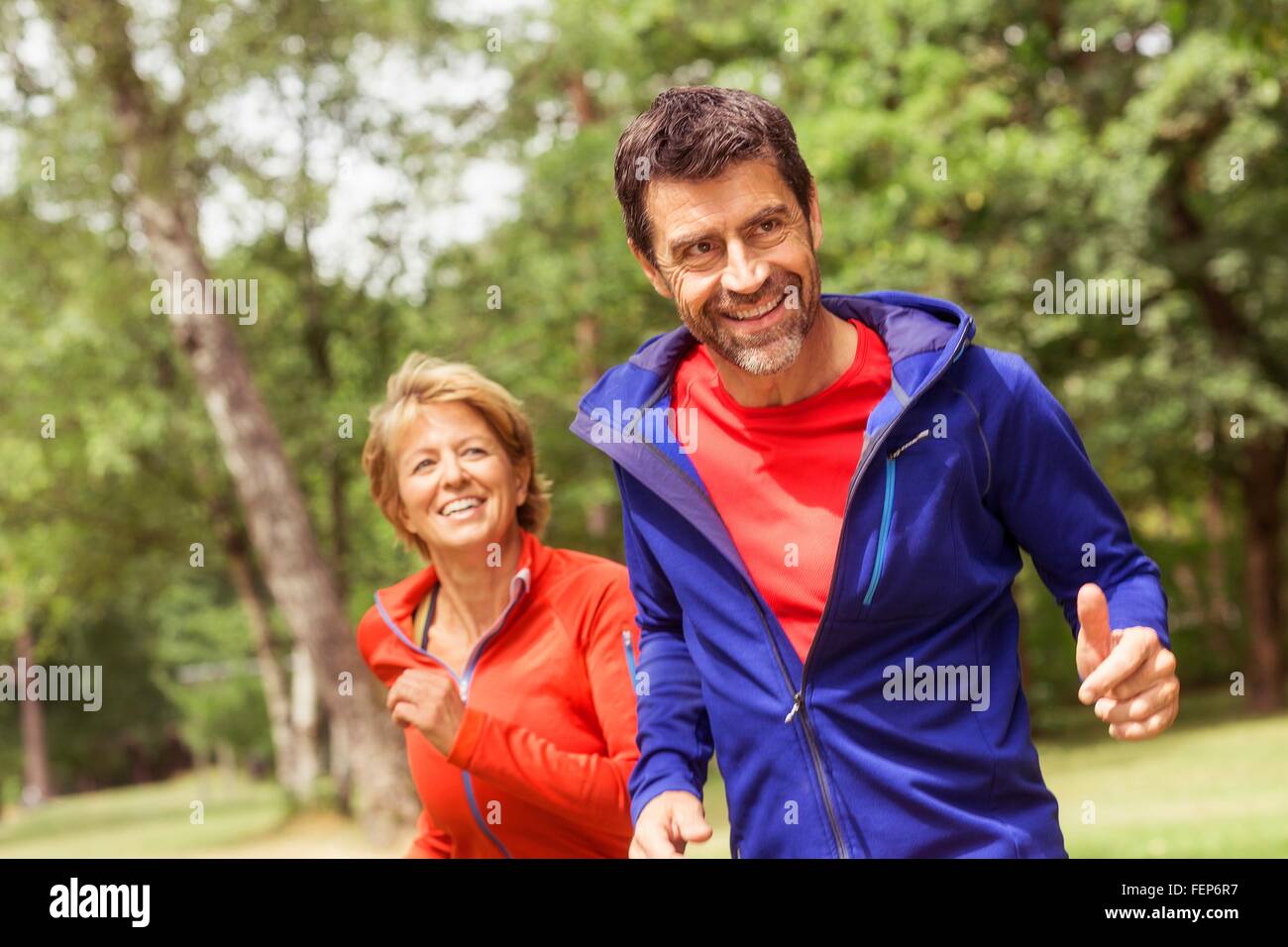 Couple running outdoors, smiling Stock Photo