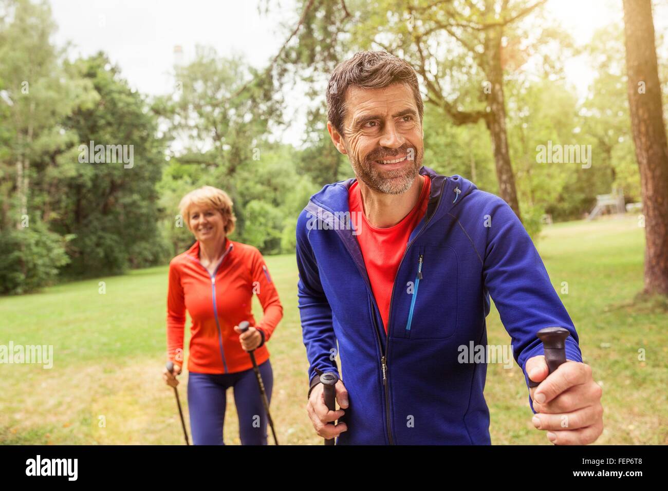 Couple walking outdoors, using walking poles Stock Photo