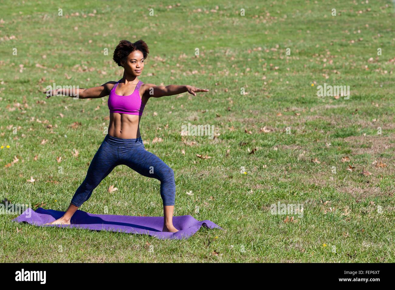 Young woman doing yoga in park Stock Photo - Alamy