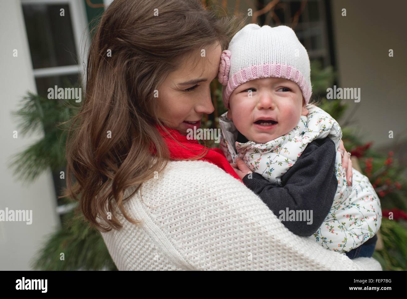 Young girl, crying, being consoled by mother, outdoors Stock Photo
