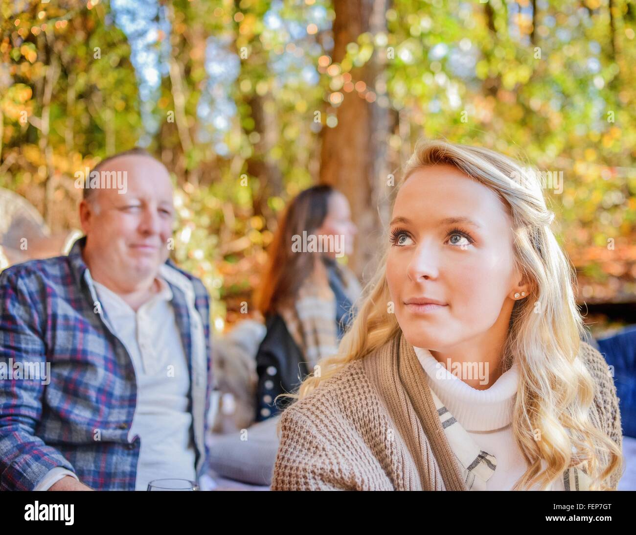 Portrait of young woman with parents in woods Stock Photo